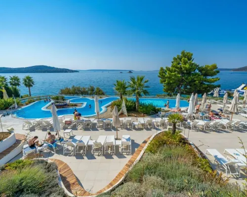 Piscina e lettini con vista sul mare al campeggio Roan Amadria Park Trogir.